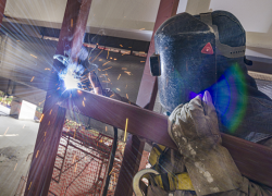 A worker in Mexico welds a metal joist.