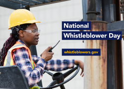 A female worker wearing a hard hat and safety goggles uses a walkie-talkie while sitting in a forklift or similar vehicle. The text reads "National Whistleblower Day, whistleblowers.gov"