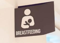 Photo of a nursing room, with a sign reading "Breastfeeding"