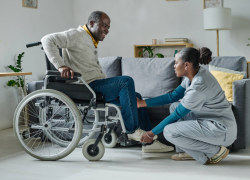 A care worker helps an older person in a wheelchair