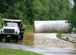 A white truck on a flooded roadway. 