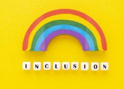 A rainbow against a yellow background with the word Inclusivity.