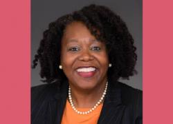 Headshot of Representative Kim Schofield, a smiling Black woman in a bright shirt and blazer, a pearl necklace and earrings.
