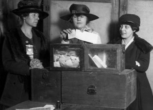 Three Wyoming women cast ballots in an undated black and white photo.
