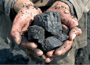 A person holding coal in their hands.