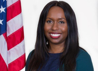 Official portrait of Melanie Calhoun with an American flag in the background.