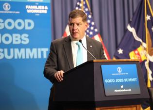 Secretary Walsh stands at the podium for the Good Jobs Summit