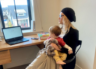 Nichole and her son sit at her desk