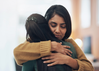 Two people hugging and consoling each other.