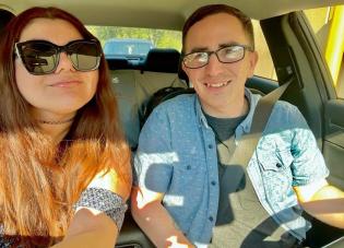 Anthony and Yasmin sit in a car.