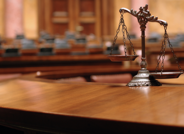 La balanza de la justicia sobre un escritorio en una sala del tribunal.